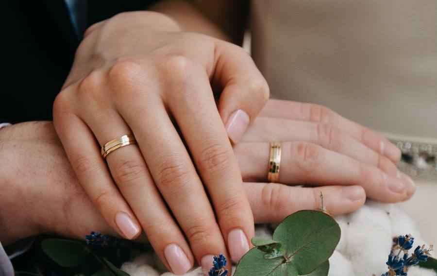 Wedding rings on the hands of the newlyweds